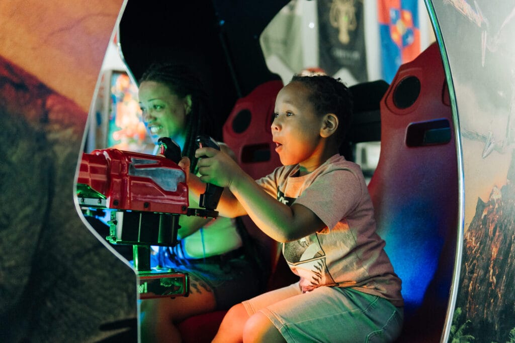 Family members playing an arcade game at Uptown Pinball